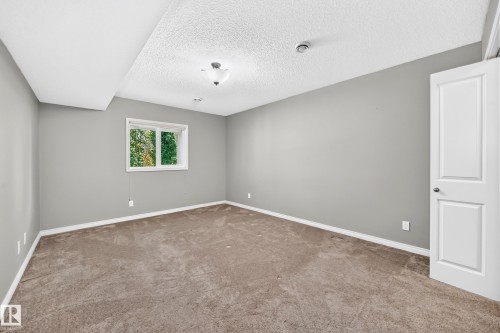 Soft grey wall paint, neutral carpet flooring, and a white window frame with integrated pane - 21 Silverstone Drive, Stony Plain, AB 