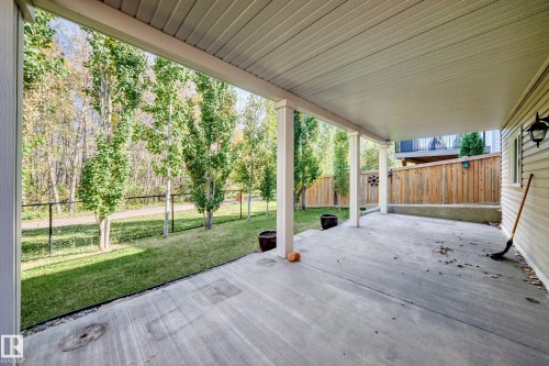 Covered concrete patio with white support columns, white soffit ceiling, and siding exterior - 21 Silverstone Drive, Stony Plain, AB 