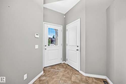 White paneled door with a glass insert, tile flooring, and light gray walls - 21 Silverstone Drive, Stony Plain, AB 