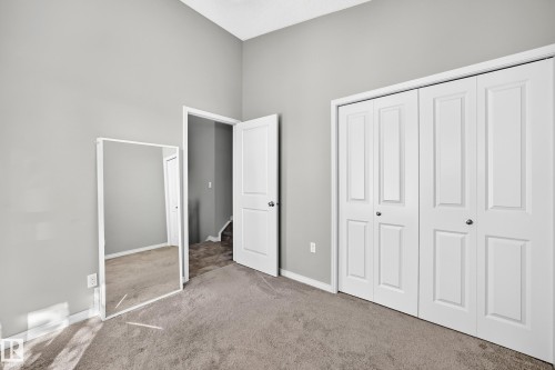 Vaulted ceiling, neutral wall paint, carpet flooring, paneled interior door, bi-fold closet doors - 21 Silverstone Drive, Stony Plain, AB 