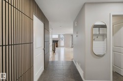Foyer featuring slate-style floor tiles, a textured accent wall, and a neutral color palette - 
