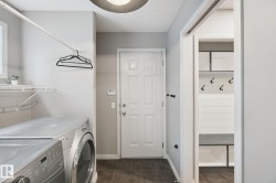 Entryway featuring a paneled door, dark tile flooring, and a built-in storage unit with shelving and wall hooks - 
