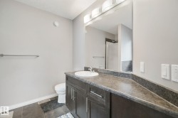 Built-in vanity with a single basin, dark wood-finish cabinetry, and a stone-finish countertop - 