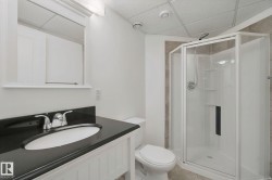 White shaker vanity with a black countertop and chrome faucet - 