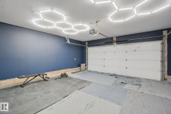 Interior space featuring a white sectional garage door and a blue accent wall - 