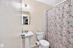Pedestal sink with chrome fixtures, an overhead vanity light, and a wall-mounted mirror - 