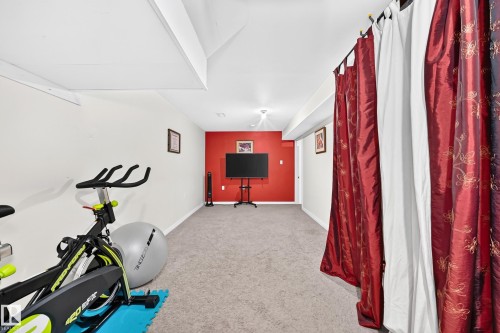 Carpeted flooring, recessed lighting, white walls, a red accent wall, and a white ceiling - 11007 173A Avenue Nw, Edmonton, AB 