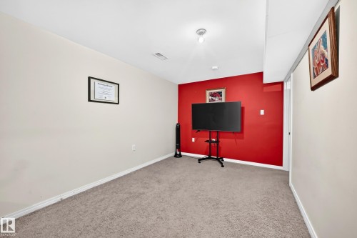 Carpeted flooring, white trim, and a prominent red accent wall - 11007 173A Avenue Nw, Edmonton, AB 