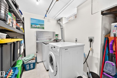 Dedicated laundry area with light-toned flooring, white walls, and built-in shelving - 11007 173A Avenue Nw, Edmonton, AB 