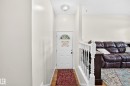Recessed entry with wood-finish flooring, white paneled door with an arched glass insert, and a ceiling-mounted light fixture - 11007 173A Avenue Nw, Edmonton, AB 