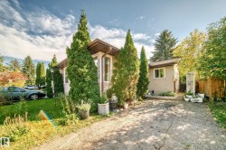 Single-story exterior with stucco and siding elements, featuring a bay window, a paved driveway, and mature landscaping - 