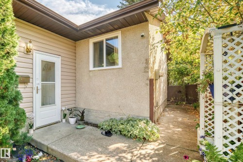 Concrete entry porch with an exterior light fixture, horizontal vinyl siding, and a white storm door - 11007 173A Avenue Nw, Edmonton, AB 