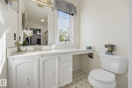 White vanity with integrated sink, chrome faucet, and expansive counter space - 17072 67 Avenue Nw, Edmonton, AB 