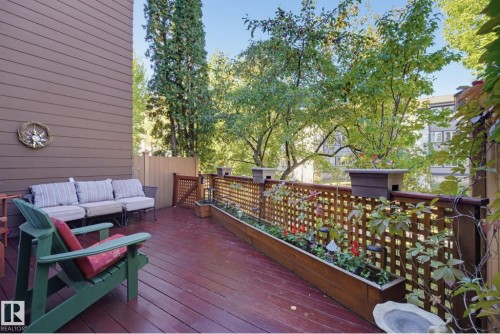 Expansive outdoor deck with wood flooring, privacy lattice, integrated planter boxes, and wood-paneled siding - 17072 67 Avenue Nw, Edmonton, AB 