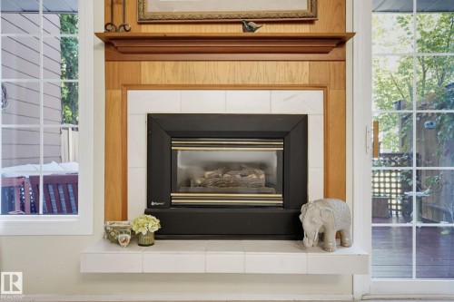 Built-in fireplace with a tile surround and hearth, featuring a wood mantel - 17072 67 Avenue Nw, Edmonton, AB 