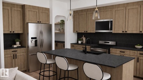 Kitchen featuring wood-finish cabinetry, dark countertops, stainless steel appliances, and a central island with an integrated sink - 28 Brickyard View, Stony Plain, AB 
