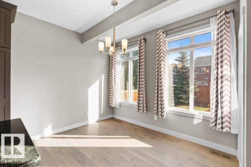 Wood-finish flooring, two large windows, and a built-in light fixture - 1523 168 Street Sw, Edmonton, AB 