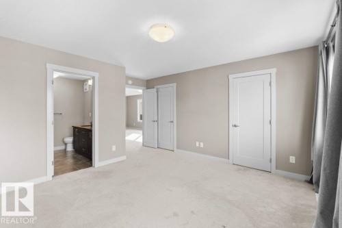 Neutral wall paint, light-colored carpeting, white interior doors, and a flush mount ceiling light fixture - 1523 168 Street Sw, Edmonton, AB 