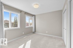 Light gray wall paint, two windows with white trim, flush mount ceiling light, and light-colored carpet flooring - 