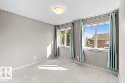 Plush carpeting, neutral wall tones, two large windows, and a flush-mount ceiling light fixture - 1523 168 Street Sw, Edmonton, AB 