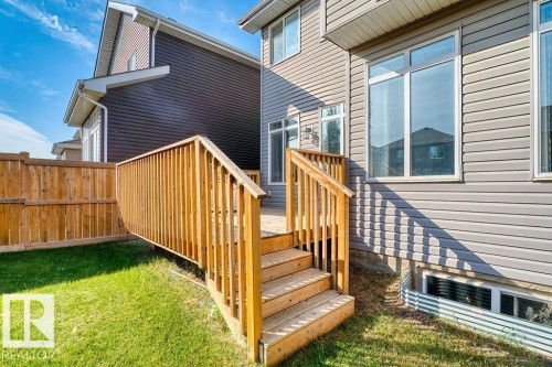 Private wooden deck with stairs to a grassed yard, featuring a privacy fence and exterior siding - 1523 168 Street Sw, Edmonton, AB 