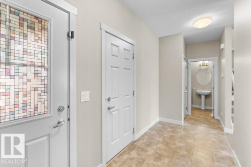 Entryway featuring patterned glass door, neutral wall paint, and tile flooring - 1523 168 Street Sw, Edmonton, AB 