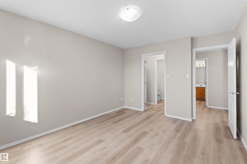 Neutral wall tones, wood-finish flooring, and white trim - #408 10610 76 St Nw, Edmonton, AB 