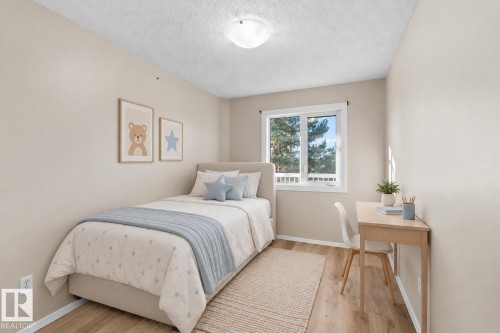 Neutral-toned walls, wood-finish flooring, and a window with white trim - #408 10610 76 St Nw, Edmonton, AB 