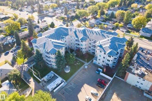 Multi-story apartment building with a multi-gable roof design, multiple balconies, and an on-site parking area - #408 10610 76 St Nw, Edmonton, AB 
