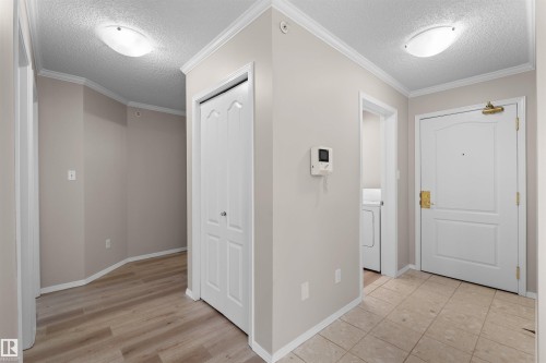 Entryway featuring tile flooring, a built-in closet with bifold doors, and a ceiling-mounted light fixture - #408 10610 76 St Nw, Edmonton, AB 
