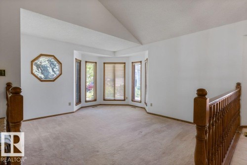 Vaulted ceiling, bay window, light wood window trim, light wood railing, and an octagonal decorative window - 507 Burton Close Nw, Edmonton, AB 