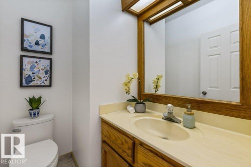 White toilet with a built-in tank - 507 Burton Close Nw, Edmonton, AB 