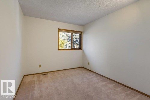 Room with neutral wall color, light-toned carpeting, and a window with wood trim - 507 Burton Close Nw, Edmonton, AB 
