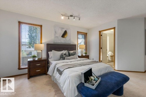 Carpeted flooring throughout, track lighting fixture, wood-trimmed windows with blinds, and a doorway leading to another room - 507 Burton Close Nw, Edmonton, AB 