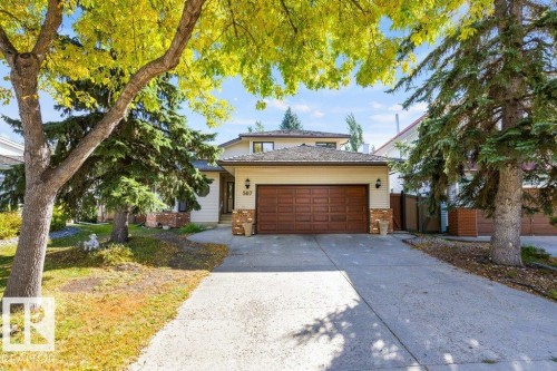 Property exterior with a concrete driveway, attached garage, and stone facade accents - 507 Burton Close Nw, Edmonton, AB 