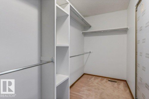 Built-in closet shelving, multiple hanging rods, and light-toned carpeting - 507 Burton Close Nw, Edmonton, AB 