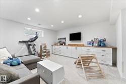 Recessed lighting, wall-mounted television, built-in cabinetry with wood-finish countertop, and carpeted flooring - 