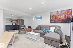 Recessed lighting, wood-finish open shelving, built-in lower cabinetry, a stainless steel refrigerator, and a window provide functional and aesthetic elements - 