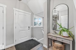 Entryway featuring wood-finish flooring, a white paneled door, and a transom window - 