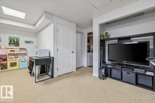 Carpeted flooring with white painted walls and ceiling, featuring a rectangular ceiling light fixture - 1040 Lakewood Rd N Nw, Edmonton, AB 