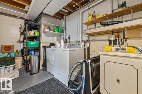 Dedicated laundry area featuring a utility sink and exposed ceiling joists - 1040 Lakewood Rd N Nw, Edmonton, AB 