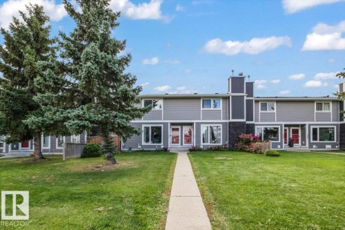 Two-story multi-unit structure with gray siding, contrasting trim, and red entry doors - 1040 Lakewood Rd N Nw, Edmonton, AB 