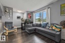 Hardwood-style flooring throughout, an expansive window, and a built-in railing - 1040 Lakewood Rd N Nw, Edmonton, AB 
