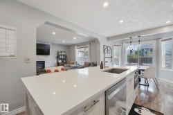 Kitchen island with a built-in stainless steel sink, integrated dishwasher, and white countertop - 