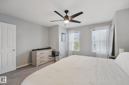 Carpeted bedroom featuring two windows with blinds, a ceiling fan with light, and a solid white door - 324 Ascott Crescent, Sherwood Park, AB 