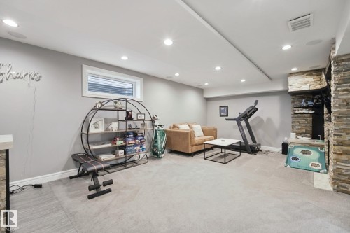 Recessed lighting, light gray carpeting, stone veneer accent wall, and a horizontal window - 324 Ascott Crescent, Sherwood Park, AB 