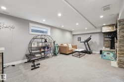 Recessed lighting, light gray carpeting, stone veneer accent wall, and a horizontal window - 