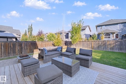 Expansive backyard featuring a wood-plank deck, a patio area, a manicured lawn, and a wood privacy fence - 324 Ascott Crescent, Sherwood Park, AB 