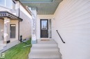Pillared front entryway with a dark-paneled door, concrete steps, and a black handrail - 324 Ascott Crescent, Sherwood Park, AB 