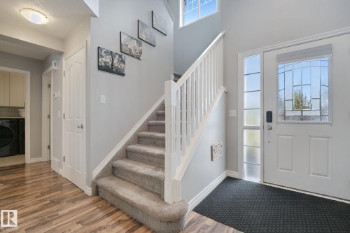 Entryway featuring a white paneled door with decorative glass, a sidelight, and wood-finish flooring - 324 Ascott Crescent, Sherwood Park, AB 